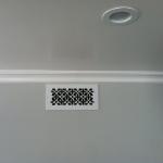 Heritage resin grille in white on gray wall 